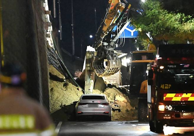 수도권 등 중부지역에 호우주의보가 발효된 16일 오후 경기 오산시 가장교차로 고가도로 옹벽이 무너져 소방관들이 매몰된 차량을 구조작업하고 있다. 2025.07.16 뉴시스