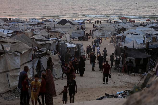 10일(현지시각) 가자시티 해변 근처 난민 텐트 주변을 사람들이 지나고 있다. 가자시티/신화 연합뉴스