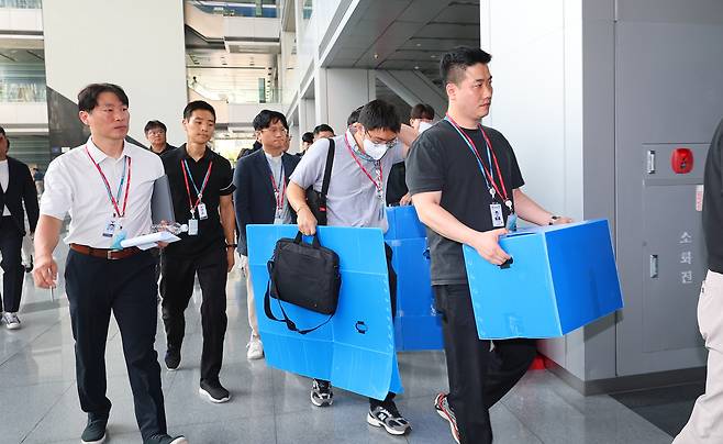 Officials from the Gyeonggi Nambu Provincial Police Agency and the Ministry of Employment and Labor enter Posco Eco & Challenge’s headquarters in Incheon on Aug. 12 to conduct a raid in connection with the electrocution of a worker from Myanmar at the company’s highway construction site in Gwangmyeong, Gyeonggi. [YONHAP]