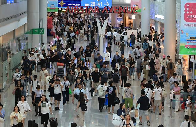 Travelers move through the duty-free zone at Incheon International Airport on July 23. [YONHAP]