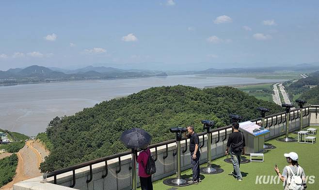 12일 경기도 파주시 탄현면에 위치한 오두산 통일전망대에서 관광객들이 망원경을 통해 북한지역을 살펴보고 있다. 서울의 젖줄인 한강과 북한에서 흘러내려오는 임진강이 합류하는 지점에 자리잡고 있는 오두산 전망대는 지리적 특성 덕분에 이곳에서는 날씨가 맑은 날이면 북한 개성의 송악산과 그 일대를 육안으로 관찰할 수 있다. 남쪽으로는 서울 도심의 63빌딩까지 조망이 가능하다.&nbsp;