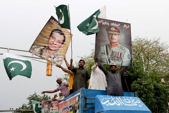 5월 15일 파키스탄 육군 참모총장 아심 무니르(오른쪽)의 사진이 담긴 포스터를 든 사람들이 파키스탄 군대의 육군 참모총장 아심 무니르(R)와 파키스탄 군대 합동참모본부 공보국장 아흐메드 샤리프 차우드리와 함께 파키스탄 육군을 지지하는 집회에서 행진하고 있다. /로이터=뉴스1