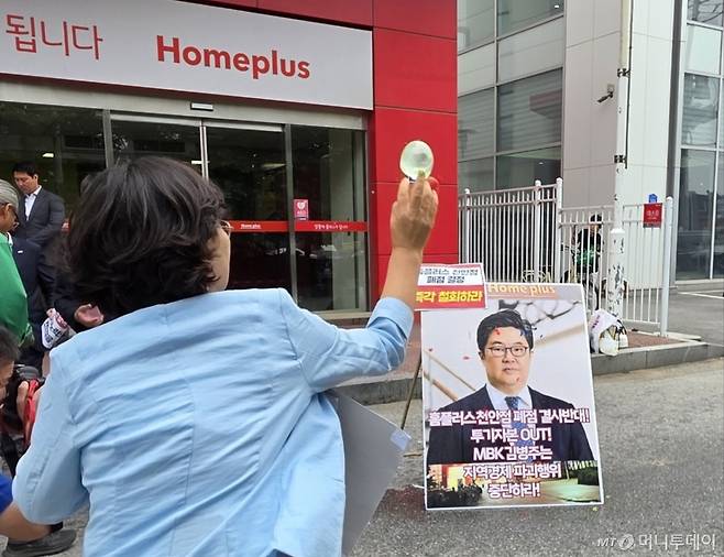 마트 노동자들이 지난 6월 2일 천안시 동남구 홈플러스 천안점 앞에서 열린 폐점 반대 기자회견에서 김병주 MBK파트너스 회장을 규탄하며 얼굴 사진에 물풍선을 던지고 있다. /사진제공=뉴스1
