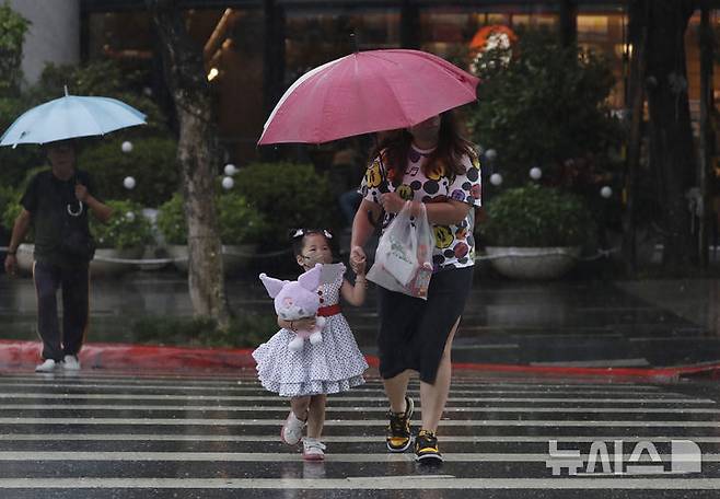 [타이베이=AP/뉴시스] 올해 제11호 태풍 ‘버들’이 13일 정오 전 대만에 상륙할 것으로 예상되면서 대만과 중국 양측이 태풍 경보를 발령하고 비상 대비에 나섰다. ‘버들’은 북한이 제출한 이름이다. 사진은 지난 7월 7일 대만 타이베이시에서 사람들이 빗속을 걷는 모습. 2025.08.13