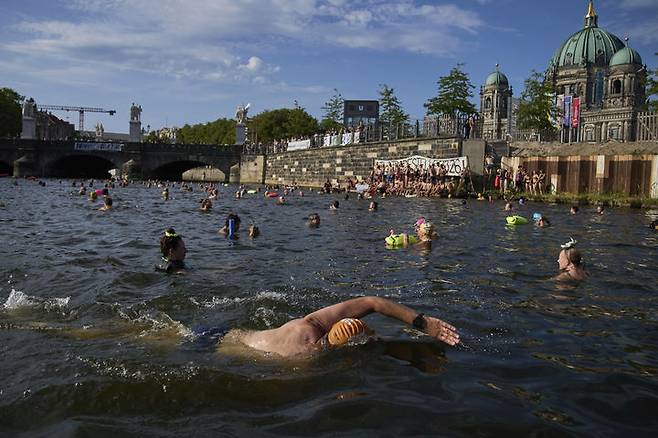 [베를린=AP/뉴시스] 12일(현지 시간) 독일 베를린에서 시민들이 슈프레강 수영 금지 해제를 촉구하며 강에서 수영하고 있다. 슈프레강은 수질 오염에 따른 보건 위험으로 100년 넘게 수영이 금지됐다. 시민 단체 등은 슈프레강이 수영할 만큼 수질이 개선됐다면서 수영 허용을 촉구하고 있다. 2025.06.18.