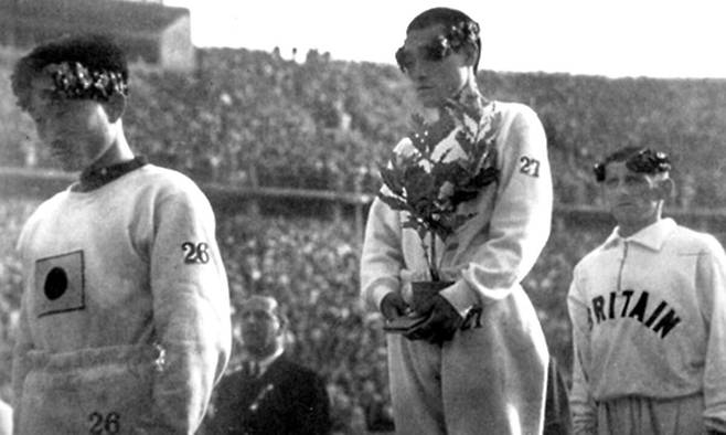 1936년 독일 베를린 올림픽 마라톤 시상식 모습. 금메달을 딴 손기정 선수(가운데)와&nbsp;동메달 수상자인 남승룡 선수(왼쪽)의 표정이 어둡다. 오른쪽은 은메달리스트 에른스트 하퍼&nbsp;선수(영국).&nbsp;SNS&nbsp;캡처