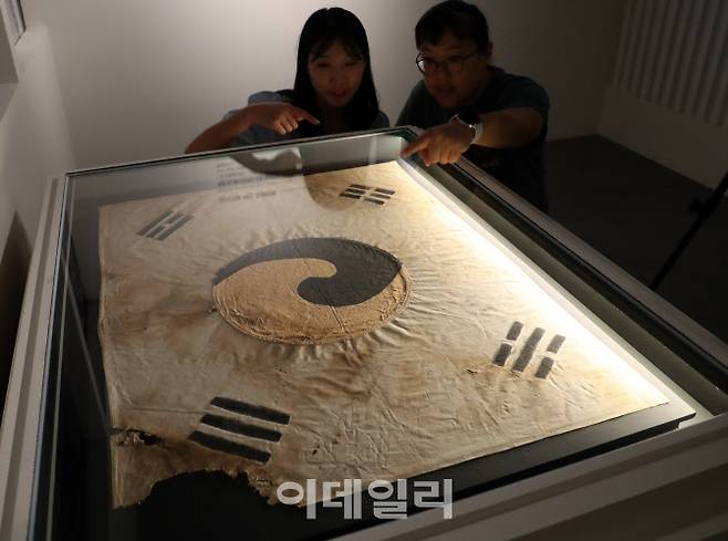 국가유산청이 광복 80주년을 맞아 덕수궁 돈덕전에서 개최하는 특별전 ‘빛을 담은 항일유산’ 특별전 언론공개회가 11일 열렸다. 참석자들이 보물 ‘서울 진관사 태극기’를 관람하고 있다. (사진=김태형 기자)