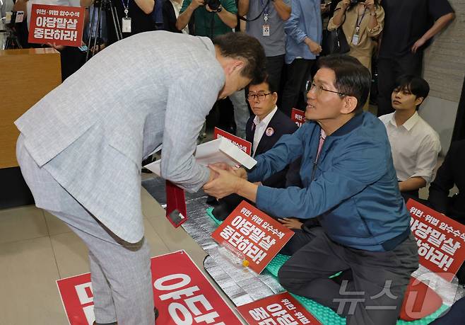 국민의힘 전당대회 합동연설회를 방해해 당 윤리위원회에 회부된 한국사 강사 전한길 씨가 14일 서울 여의도 중앙당사에서 열린 윤리위원회에 참석하기 전 농성중인 김문수 당대표 후보와 인사하고 있다. (공동취재) 2025.8.14/뉴스1 ⓒ News1 안은나 기자