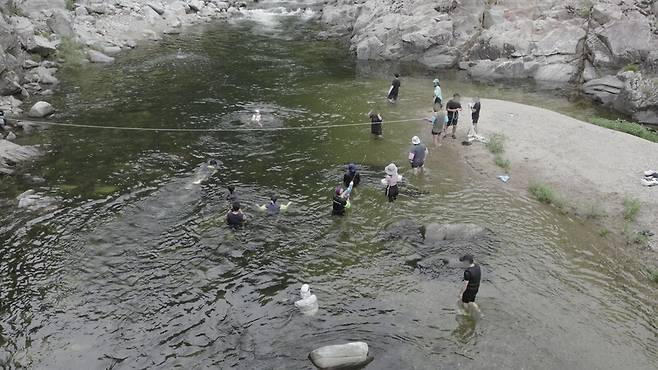 지난 12일 국내 최대의 생태경관보전지역인 왕피천의 깊은 웅덩이에서 방문객들이 물놀이하고 있다. 녹색연합 제공