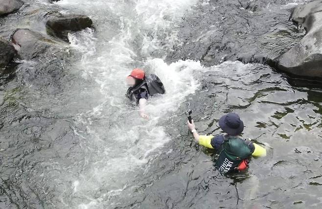 지난 12일 국내 최대의 생태경관보전지역인 왕피천의 급류에서 방문객들이 물놀이하고 있다. 녹색연합 제공