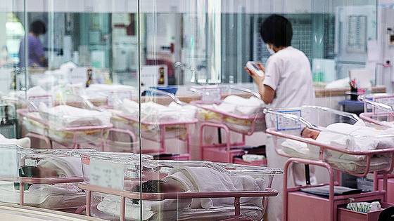 서울 시내 한 산후조리원 신생아실에서 한 관계자가 신생아를 돌보고 있다. 연합뉴스