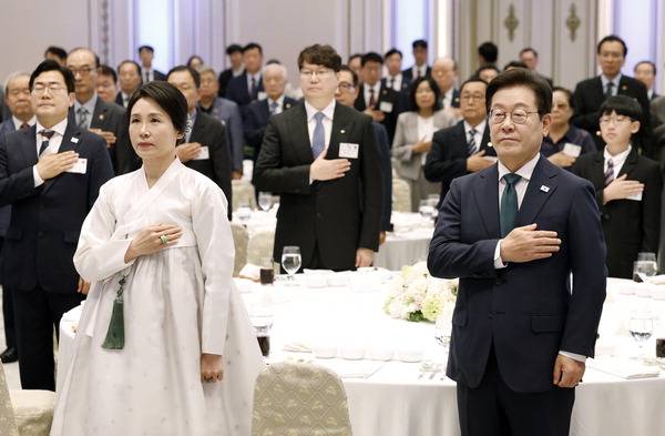 이재명 대통령과 김혜경 여사가 14일 청와대 영빈관에서 열린 ‘광복 80주년, 대통령의 초대’ 행사에서 참석자들과 국기에 경례하고 있다. 연합뉴스