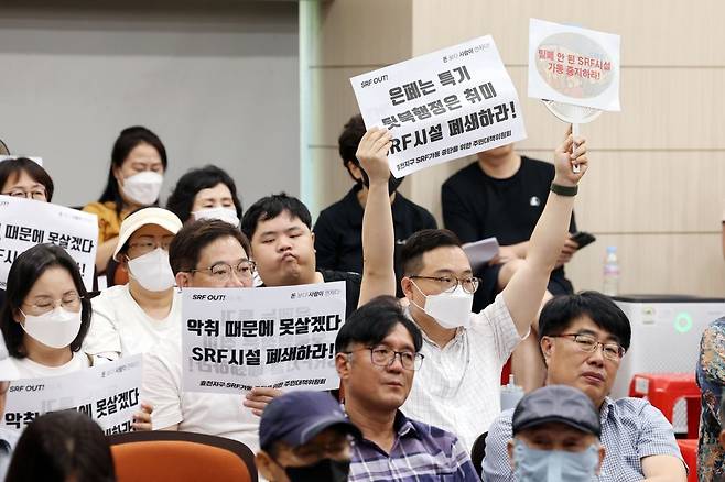 14일 오전 광주 남구 양과동 광역위생 매립장 내 가연성폐기물 연료화시설(SRF)에서 열린 '악취 해결을 위한 간담회'에서 주민들이 손팻말을 들고 있다. 연합뉴스