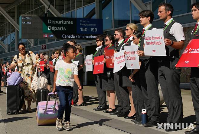 [밴쿠버=신화/뉴시스] 8월11일 캐나다 브리티시컬럼비아주 리치먼드 밴쿠버 국제공항에서 에어캐나다 승무원들이 전국 행동의 날을 맞아 침묵시위를 하고 있다.  에어 캐나다는 결국 16일 총파업에 대비해 항공편 취소를 시작했다.  2025.08.14.