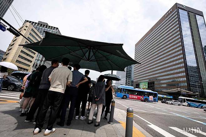 7월30일 서울 광화문 사거리 건널목 앞 무더위 그늘막에서 사람들이 신호를 기다리고 있다. ⓒ시사IN 이명익