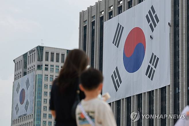 정부서울청사와 외교부 외벽에 걸린 대형 태극기 (서울=연합뉴스) 신현우 기자 = 광복절을 나흘 앞둔 11일 정부서울청사(오른쪽) 외벽에는 대형 태극기가, 외교부에는 김구 서명문 태극기가 걸려 있다. 2025.8.11 nowwego@yna.co.kr