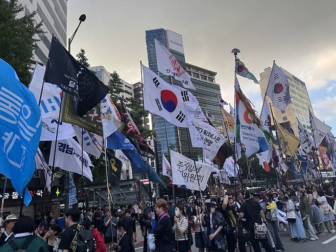 15일 서울 중구 숭례문 앞에서 열리는 8·15범시민대회 집회에 참여하는 시민들이 태극기와 각양각색의 깃발을 들고 집회가 시작되길 기다리고 있다. 정봉비 기자