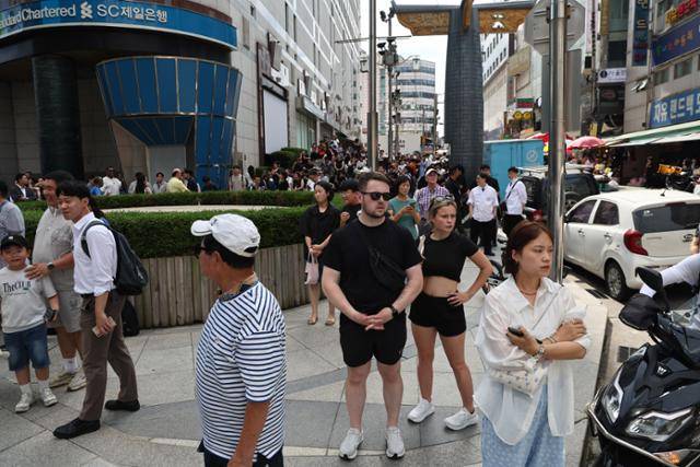 5일 서울 중구 명동 신세계백화점 본점에 폭발물을 설치했다는 협박 글이 인터넷 커뮤니티에 올라와 경찰이 수색에 나선 가운데 사람들이 건물 밖으로 대피해 있다. 연합뉴스