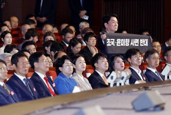 국민의힘 안철수 의원이 15일 서울 세종문화회관에서 열린 80주년 광복절 경축식에서 이재명 대통령이 경축사를 마치고 자리로 향할 때 ‘조국·윤미향 사면 반대’라는 문구가 적힌 펼침막을 들어보이고 있다. 연합뉴스