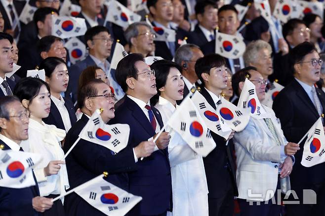 [서울=뉴시스] 최동준 기자 = 이재명 대통령과 김혜경 여사가 15일 서울 종로구 세종문화회관에서 열린 제80주년 광복절 경축식에서 참석자들과 광복절 노래를 제창하며 태극기를 흔들고 있다. 2025.08.15. photocdj@newsis.com