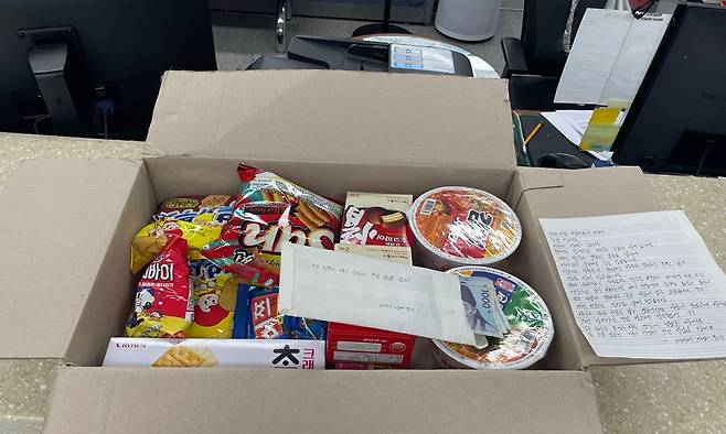 익명의 기부자가 경찰 지구대 앞에 두고 간 상자에서 발견된 손 편지와 라면·과자·지폐가 든 상자. 부산 북부경찰서 제공