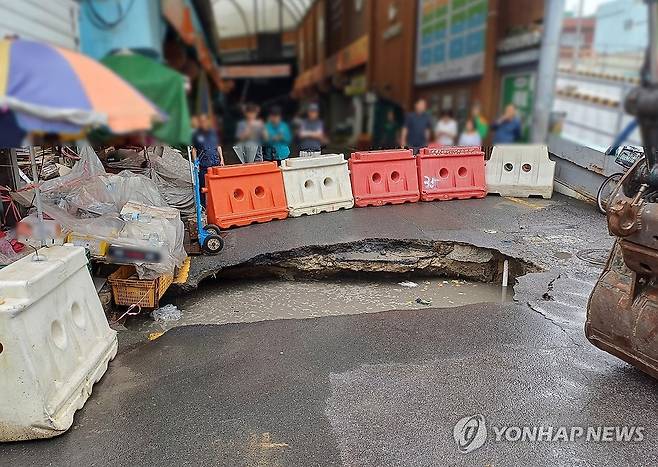 시장 입구 대형 땅 꺼짐 (부산=연합뉴스) 지난 12일 오전 부산 사상구 새벽시장 정만 앞 도로에 세로 5ｍ, 가로 1ｍ 크기의 대형 땅 꺼짐(싱크홀) 현상이 발생했다. 2025.8.12 [부산경찰청 제공. 재판매 및 DB 금지] pitbull@yna.co.kr