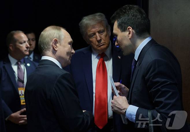 도널드 트럼프 미국 대통령(가운데)이 15일 알래스카주 앵커리지의 엘먼도프-리처드슨 합동 기지에서 블라디미르 푸틴 러시아 대통령(왼쪽)과 통역을 사이에 두고 대화하고 있다. 2025.8.15 ⓒ AFP=뉴스1 ⓒ News1 강민경 기자