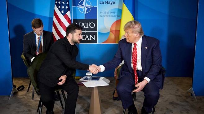 지난 2월 백악관 회담 당시 양복 정장 대신 티셔츠 차림으로 도널드 트럼프 미 대통령과 만나 서로 고함을 지르는 등 격렬한 말다툼을 벌였던 볼로디미르 젤렌스키 우크라이나 대통령이 25일 네덜란드 헤이그에서 열린 북대서양조약기구(나토) 정상회의에서 트럼프와 만난 2번째 회담에서는 티셔츠 대신 양복을 착용했다고 뉴욕 포스트가 26일 보도했다. 25일 트럼프 대통령과 회담하는 젤렌스키 대통령.  2025.06.26. 사진 출처 : 키이우 포스트. 뉴시스