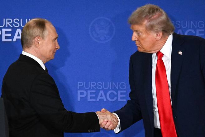 15일 도널드 트럼프 미국 대통령과 블라디미르 푸틴 러시아 대통령이 알래스카 앵커리지의 엘먼도프-리처드슨 합동기지에서 열린 미국-러시아 우크라이나 정상회담을 마친 뒤 공동 기자회견에서 악수하고 있다. 앵커리지/AFP 연합뉴스