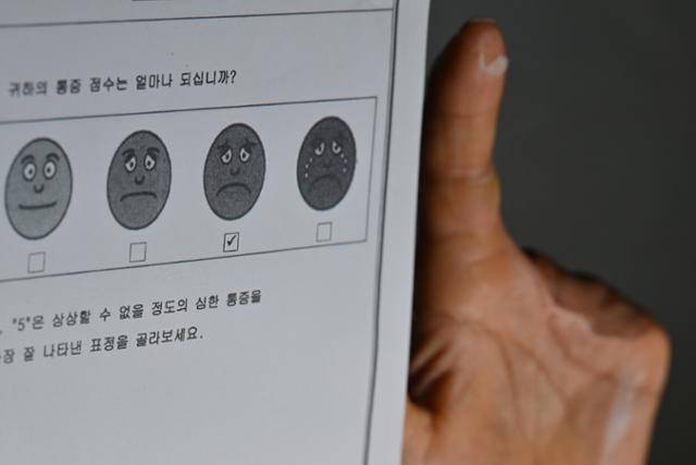 5일 충남 금산군의 한 카페에서 산재 피해를 입은 이주노동자 수메스 바르마씨가 영구 장해를 입은 손으로 병원 진료 당시에 체크한 '통증점수'가 적힌 종이를 들고 있다. 최주연 기자