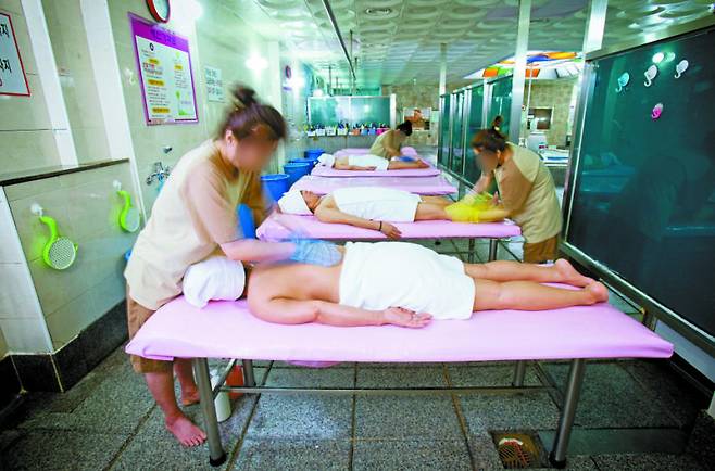 Seshinsa scrub customers at a bathhouse in 2015. [JOONGANGILBO]