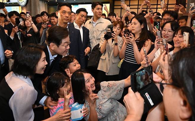 이재명 대통령과 김혜경 여사가 17일 서울 용산구 CGV에서 영화 '독립군:끝나지 않은 전쟁'을 관람한 뒤 상영관을 나서며 시민들과 기념촬영을 하고 있다./연합뉴스