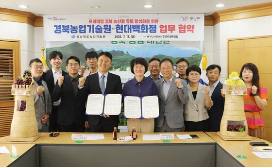경상북도농업기술원과 현대백화점이 지난달 18일 '프리미엄 경북 농산물 유통 활성화 업무협약'을 체결했다. 조영숙 경상북도농업기술원장(앞줄 오른쪽)과 장우석 현대백화점 상무가 업무협약서를 들어보이고 있다. 사진 경상북도농업기술원