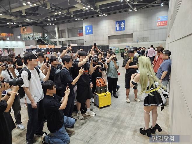 지난 2일 오후 경기도 고양시 일산 킨텍스에서 열린 세계 최대 피규어·조형 아트 행사 '원더페스티벌 2025'에서 시프트업의 '승리의 여신: 니케' 속 메이드를 코스프레한 여성을 관람객들이 사진 촬영하고 있다. 사진=박수빈 기자