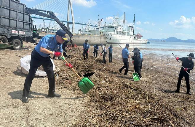 서해지방해양경찰청 특공대원들과 목포해경 직원들이 지난달 23일 오전 전남 목포시 동명동 동명항 일대에서 집중호우로 발생한 해양 쓰레기를 수거하고 있다. 서해지방해양경찰청 제공