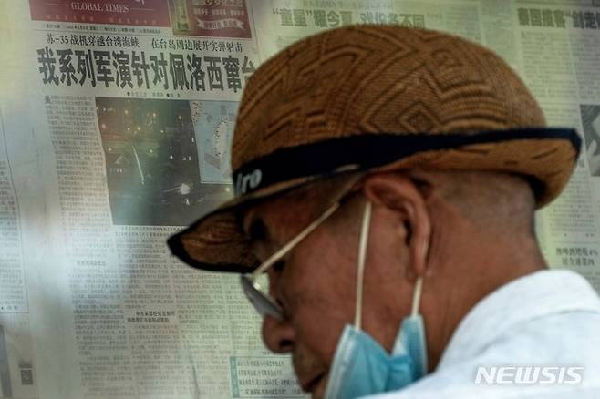 [베이징=AP/뉴시스] 지난 2022년 8월 3일 중국 베이징의 신문 게시판에서 한 노인모습.