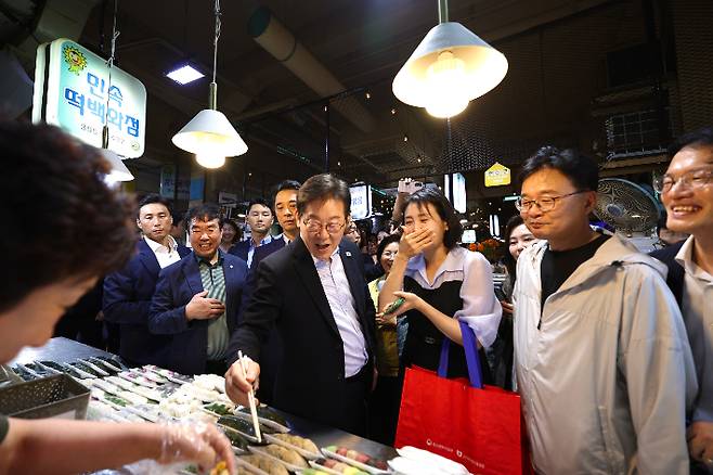 이재명 대통령과 김혜경 여사가 17일 서울 은평구 연서시장을 방문해 한 매장에서 떡을 시식하고 있다. 대통령실 제공