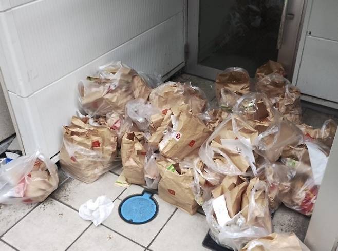 일본 맥도날드는 최근 어린이용 메뉴 ‘해피 세트’ 구매자에게 1세트당 포켓몬 카드 2장을 주는 이벤트를 열었다가 ‘리셀러’들 때문에 골머리를 앓았다. 사진은 도쿄의 한 맥도날드 매장 근처 건물 앞에 쌓인 버려진 음식 봉투들. 엑스 계정 ‘hitsutsu_08’ 캡처