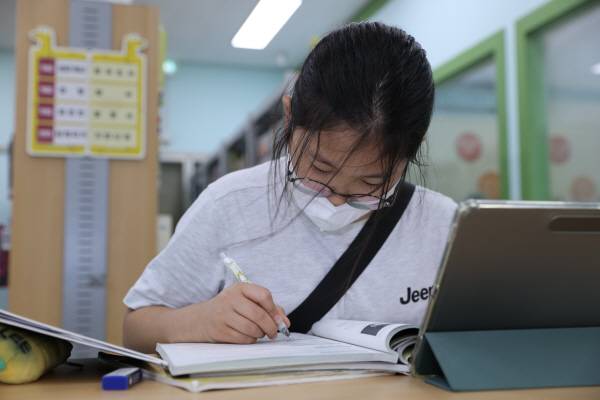 18일 대구 남부도서관에서 한 아이가 필기구를 손에 쥐고 뭔가를 적고 있다.김영환 기자 yhk@kyongbuk.com