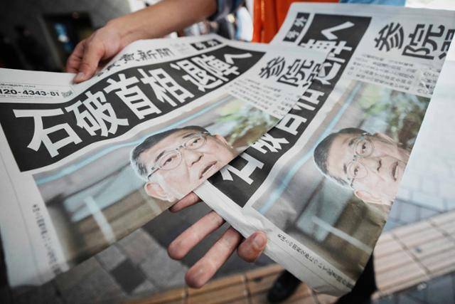 일본 최다 부수 발행 언론사인 요미우리신문의 한 직원이 지난달 23일 도쿄 도내에서 '이시바 총리 퇴진'이라는 제목의 기사가 실린 호외판을 배포하고 있다. 도쿄=AP 뉴시스