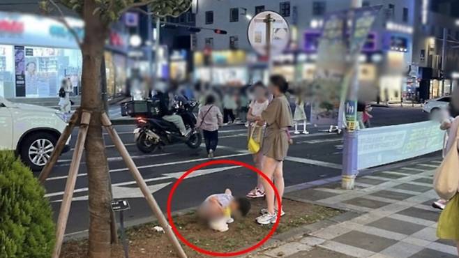 보호자로 보이는 여성 앞에서 중국인 관광객으로 추정되는 남아가 화단에 용변을 보는 모습