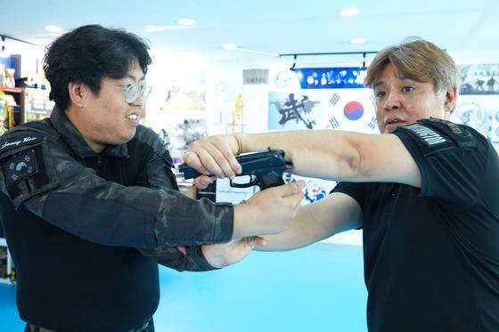 총을 제압해서 뺏는 방법 등 권총 활용 기술을 시범 보이는 김대영 대표와 김성후(왼쪽) 사범.