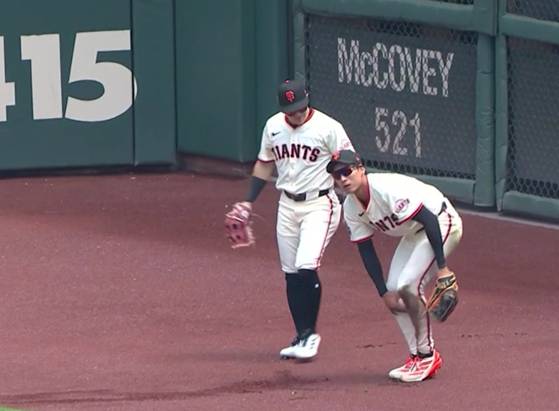 슬라이딩 과정에서 튀어나온 볼을 두 무릎으로 고정 시켜 처리한 뒤 꺼내 보여주는 이정후(오른쪽). 사진 MLB닷컴 영상 캡처