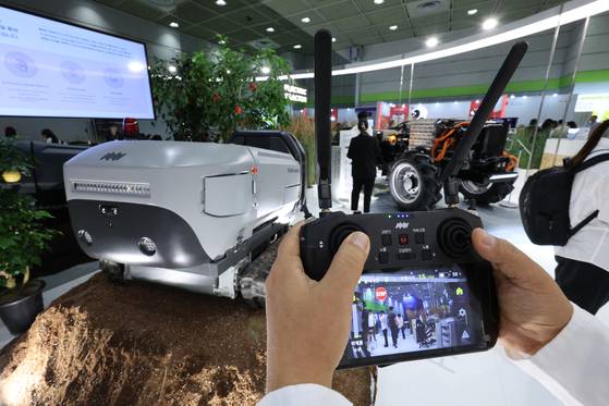 A visitor tries an agricultural drone at a tech fair held on July 16 in Coex, southern Seoul. [NEWS1]