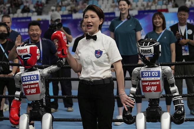 [베이징=AP/뉴시스] 16일(현지 시간) 중국 베이징 국가스피드스케이팅경기장에서 열린 2025 세계 휴머노이드 로봇 운동회 권투 경기에서 심판이 승자 선언을 하고 있다. 2025.08.18.