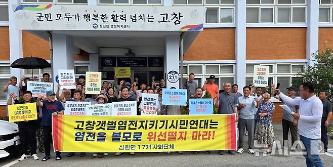 [고창=뉴시스] 김종효 기자 = 18일 고창군 심원면 사무소 앞에서 열린 지역 17개 주민단체 대표들의 '고창종합테마파크 유치·건립 찬성 기자회견', 주민 대표들이 성명서를 발표한 뒤 일부 시민단체의 반대를 위한 반대 중단, 계획대로의 사업 추진 등을 요구하며 구호를 외치고 있다. 2025.08.18. kjh6685@newsis.com