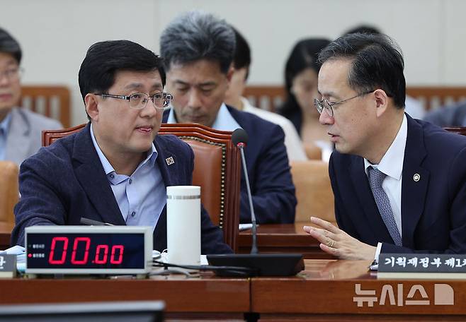 [서울=뉴시스] 김명년 기자 = 김성환 환경부 장관이 18일 오후 서울 여의도 국회에서 열린 기후위기특별위원회 전체회의에서 이형일 기획재정부 1차관과 대화하고 있다. 2025.08.18. kmn@newsis.com