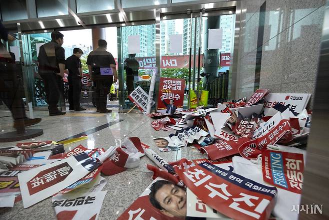 국민의힘 제6차 전당대회 부산·울산·경남 합동연설회가 8월12일 오후 부산 벡스코에서 열리는 가운데 보안요원들이 출입자들의 비표를 확인하고 있다. 바닥에는 당원들이 받아서 버리고 간 후보들의 홍보 전단지들이 널브러져 있다. ⓒ시사IN 조남진