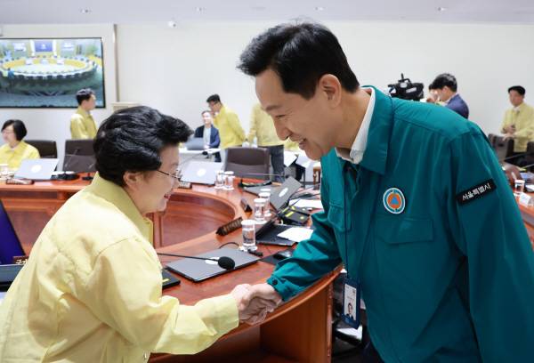 오세훈 서울시장(오른쪽)이 18일 서울 용산 대통령실 청사에서 이재명 대통령 주재로 열린 을지 국무회의에 참석해 이배용 국가교육위원장과 인사하고 있다.연합