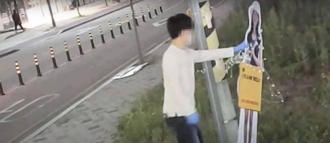 지난 5월8일 전북 전주시 완산구의 한 도로에서 40대 남성 A씨가 19년 전 전북대 수의대생 실종사건의 당사자 이윤희씨를 찾기 위해 가족들이 설치한 등신대를 넘어뜨리고 있다.ⓒ이윤희 실종사건 공식채널 유튜브 캡처